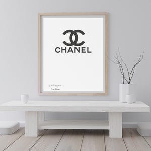 Könnte beinhalten: Ein gerahmter Druck mit dem Chanel-Logo in Schwarz auf weißem Hintergrund. Das Wort "CHANEL" ist unter dem Logo aufgedruckt. Der Druck befindet sich in einem hellen Holzrahmen und enthält den Text "I don't do fashion, I am fashion." Chanel Inspired Poster Printable, I Don’t Do Fashion I Am Fashion Quote, Luxury Fashion Decor | Personalisierung möglich!