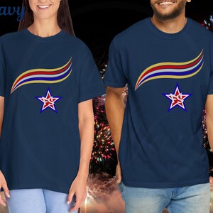 May include: Navy blue t-shirts with a star and ribbon design. The shirts feature a red, white, and gold ribbon design above a star with a red graphic inside. The word "Navy" is visible in the upper left corner.