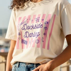 Dockside Darling Graphic Tee | Kust- och marin t-shirt | Strandälskare-tröja | Sjöliv-tröja | Preppy Seaside-kläder | Sommarsemester-tröja