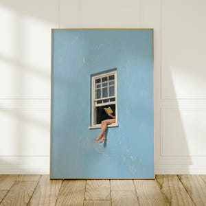May include: A rectangular wall art print featuring a light blue wall with a white-framed window. A figure sits in the window frame, holding an open yellow book. The figure's legs dangle from the window sill against the solid blue background.