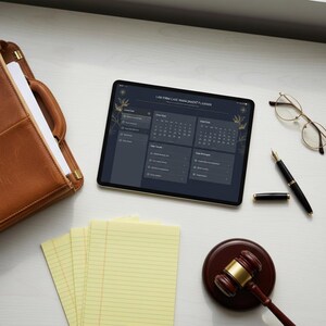 May include: A workspace scene with a tablet showing a "Law Firm Case Management Planner" interface. A brown leather portfolio, yellow legal pads, a gavel, glasses, and a pen are arranged around the tablet. The tablet has a gold-colored frame.