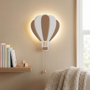May include: A wall-mounted light fixture shaped like a hot air balloon with alternating white and tan panels. The lamp emits a soft glow from behind its structure and features a vertical pull chain with a small wooden bead at the bottom end.