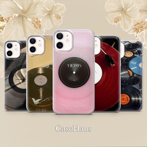 Op de afbeelding: Een verzameling telefoonhoesjes met vinylplaatontwerpen. De hoesjes tonen verschillende kleuren en plaatlabelontwerpen, waaronder een roze hoesje met de tekst "THE1975". De hoesjes zijn in een rij gerangschikt en tonen een muziekthema.