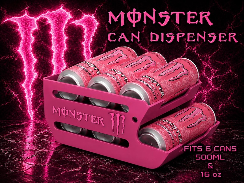 May include: A pink Monster can dispenser featuring the Monster logo and text. The unit holds six cans, with text stating it fits 500ml and 16 oz cans. The dispenser has two tiers with horizontal slots, displaying pink Monster energy drink cans inside.