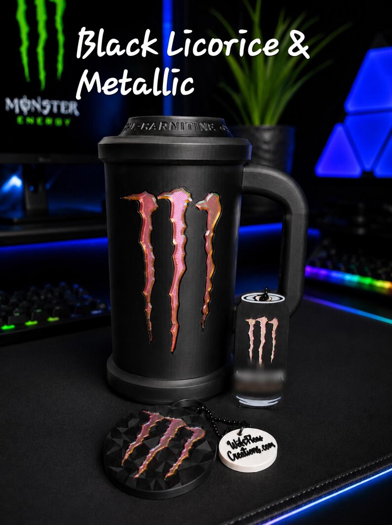 May include: A matte black mug featuring a metallic Monster Energy logo, accompanied by a matching small canister and a circular keychain with the same logo and the text "WifePleas Creations.com". The text "Black Licorice & Metallic" is visible.