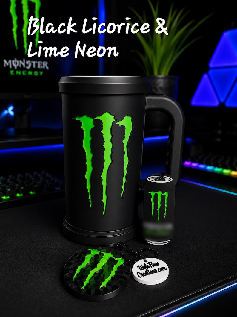 May include: A matte black cylindrical mug featuring a large neon green Monster Energy claw logo, accompanied by a small matching cylindrical keychain and a circular black and green logo keychain with a white tag reading WebFlaws Creations.com.