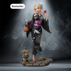 Puede incluir: Una figura de estilo anime rubia que viste un kimono negro con patrones florales blancos, un fajín obi morado y un accesorio azul en el cabello. La figura sostiene un pequeño dulce rojo y una bolsa, sobre una base de piedra con una linterna.