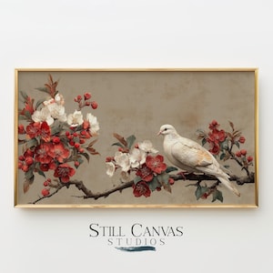 Op de afbeelding: Een ingelijste print met een witte duif op een tak met rode en witte bloesems. Het kunstwerk heeft een vintage esthetiek, een neutrale achtergrond en een gouden lijst. De tekst "Still Canvas Studios" staat onderaan.