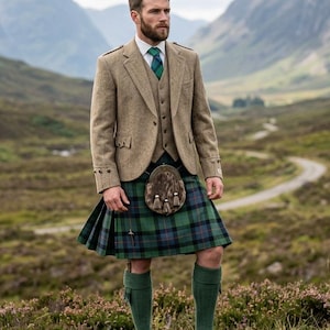 May include: A man in traditional Scottish Highland dress. He wears a tweed jacket, waistcoat, and a green and blue tartan kilt. Accessories include a sporran, green socks, and brown leather shoes. The background shows a mountain landscape.