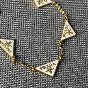 VTG Prada Milano gyllene vitt kedjearmband triangel vintage-logotyp