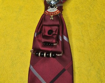 Collar con corbata roja estampada reciclada y detalles de joyas con monograma: un accesorio llamativo.