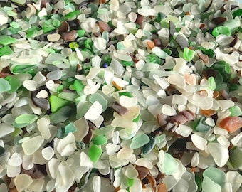 May include: A large collection of small, smooth, frosted sea glass pieces in various shapes and sizes. The assortment features a mix of colors including white, clear, light green, dark green, brown, and occasional hints of orange and black.