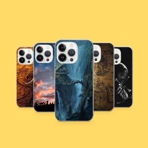 May include: Five phone cases with various designs. One case features a map, another a ring, and a third depicts a landscape with a bridge and waterfall. The other two cases have illustrations of characters. All cases are on a yellow background.