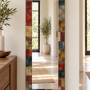 May include: A tall, rectangular wall mirror featuring a decorative frame composed of a grid of square tiles. Each tile displays a textured, concentric square pattern in a rich color palette of deep blue, metallic gold, and dark red tones.