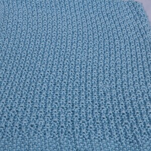 May include: A light blue knitted blanket with a textured pattern.