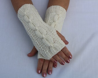 May include: A pair of white knitted fingerless gloves with a cable knit pattern.