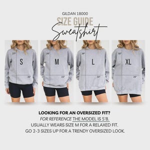May include: Size guide for a gray Gildan 18000 sweatshirt, showing measurements for sizes S, M, L, and XL. The image includes text that reads "Looking for an oversized fit?" and provides sizing recommendations.