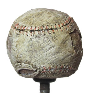 Peut inclure: Un pommeau de levier de vitesses en forme de balle de baseball usé avec des coutures rouges et une finition en cuir blanc vieilli.