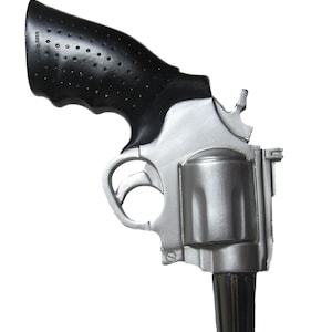 May include: A silver and black revolver-shaped beer tap handle. The handle has a black rubber grip and a silver barrel.