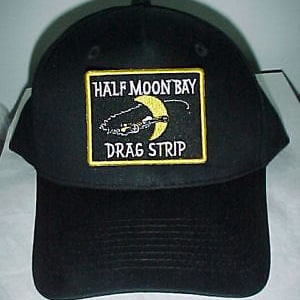 Pode incluir: Boné de beisebol preto com um remendo bordado amarelo que diz "Half Moon Bay Drag Strip".