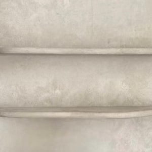 May include: Two horizontal wall-mounted shelves with a smooth, light grey concrete-like finish. Each shelf features a rounded front edge and a flat top surface, providing a clean and uniform appearance for storage or display purposes on a wall.