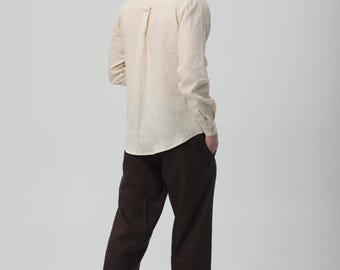 Camisa de lino beige de corte relajado para hombre, prenda informal de tejido natural, estilo minimalista.