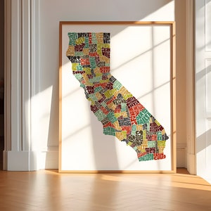 May include: A framed print of a map of California, with the state's cities and towns spelled out in a colorful, stylized font.