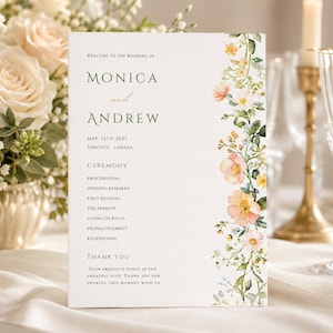 May include: A wedding program with the names "Monica and Andrew" in elegant script. The program features a floral border with peach and yellow flowers. The ceremony details are listed below the names, with a thank you message at the bottom.