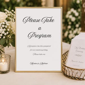 May include: A gold-framed sign with white background and black text reading Please Take a Program, A program has been prepared for our ceremony today, Please take one, and Monica & Andrew, displayed next to a basket of white programs.