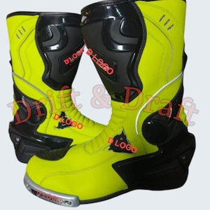 Pode incluir: Par de botas de motociclismo amarelo néon e preto. As botas têm um design de cano alto com painéis pretos reforçados na canela, tornozelo e calcanhar. As botas têm um detalhe prateado na biqueira e o texto "D LOGO" é visível.