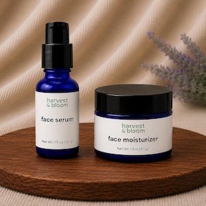May include: A blue glass bottle of face serum with a black pump and a blue glass jar of face moisturizer with a black lid. The serum label reads harvest & bloom face serum Net Wt. 1 fl oz (30 g) and the moisturizer label reads harvest & bloom face moisturizer Net Wt. 1.5 oz (43 g).