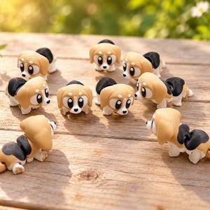 Könnte beinhalten: Eine Sammlung von neun kleinen, beweglichen Hunde-Figuren in einer beigen und schwarzen Farbgebung mit großen weißen Augen und schwarzen Pupillen. Jedes Miniatur-Hundespielzeug hat ein segmentiertes Körperdesign für flexible Bewegungen.