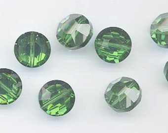 May include: Eight green glass beads with a faceted design. The beads are round and have a shiny finish.