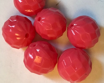 May include: Six faceted, coral-colored beads with a glossy finish. Each bead has a hole for stringing. The beads are round and have a geometric, cut-glass appearance. These beads are suitable for jewelry making and crafting.