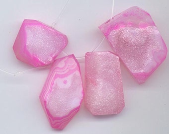 Puede incluir: Cuatro colgantes de cristal de ágata rosa con un acabado brillante y brillante. Los cristales son translúcidos y tienen una variedad de formas y tamaños.