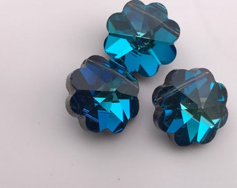 Puede incluir: Tres cuentas de cristal azules en forma de flor con un diseño facetado.