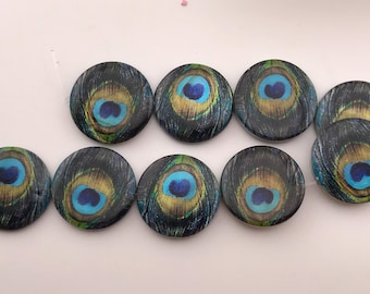 Könnte beinhalten: Eine Sammlung von neun runden Cabochons mit einem detaillierten Pfauenfeder-Augenmuster. Jedes Stück zeigt ein leuchtend blaues Zentrum, das von konzentrischen Ringen in Gold, Grün und Dunkelblau umgeben ist und ein realistisches Gefiedermuster bildet.