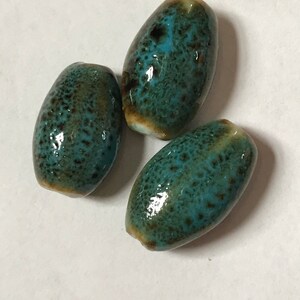 Twelve lovely porcelain/ceramic beads - aqua spattered and speckled with golden brown - 18.5 x 12 mm elongated flattened ovals