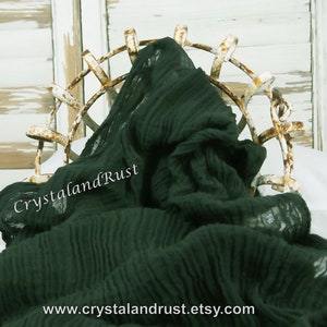 May include: A dark green, crinkled fabric draped over a metal frame. The fabric has a soft, textured look and feel. The text "CrystalandRust" is visible on the fabric. The website address "www.crystalandrust.etsy.com" is also visible.