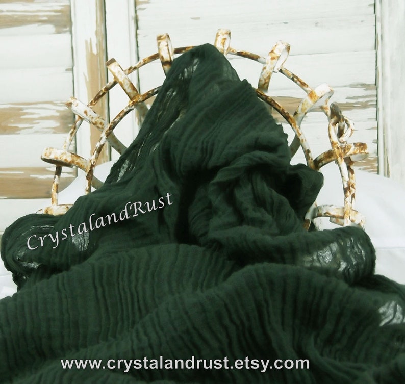 May include: A dark green, crinkled fabric draped over a metal frame. The fabric has a soft, textured look and feel. The text "CrystalandRust" is visible on the fabric. The website address "www.crystalandrust.etsy.com" is also visible.