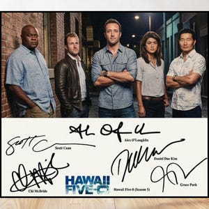 May include: A framed poster featuring a group of five people, likely actors, posing in front of a brick wall and a dark background. Below the image are signatures and the text "HAWAII FIVE-O".