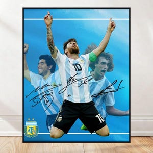 Puede incluir: Impresión enmarcada que presenta a tres futbolistas con camisetas blancas y celeste, con el número 10 visible. Los jugadores celebran con los brazos en alto. La impresión incluye firmas y el logo de la Asociación del Fútbol Argentino.