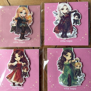 May include: Four stickers with anime-style illustrations of female characters and companions. The characters are in fantasy outfits, with details like flowing hair and ornate clothing. The stickers are on pink backgrounds, with the text "villa topo" at the bottom.