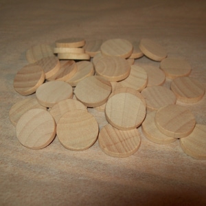 May include: A pile of natural wood craft circles, perfect for DIY projects, crafts, and games. The circles are smooth and unfinished, ready to be painted, stained, or decorated.