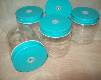 May include: Six clear glass jars with turquoise lids. The lids have a small hole in the center.