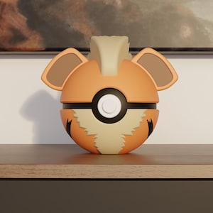 Puede incluir: Una Poké Ball naranja y beige estilizada, con un diseño que se asemeja a un Growlithe. La bola tiene una banda negra y un botón blanco. La parte superior tiene dos orejas marrones y una cresta beige.
