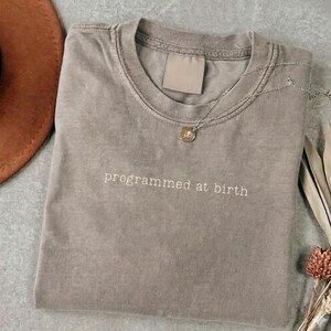 T-shirt "Programmed at Birth" - Shirt Statement Minimaliste - Streetwear Philosophique - Critique Sociale Tee - Shirt Graphique Rebels