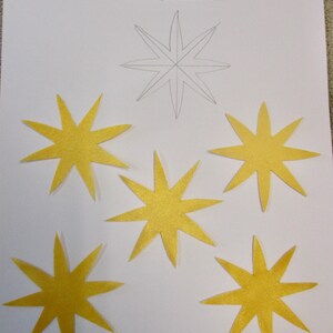 May include: Five yellow felt star appliques, each measuring 2.75 inches across, ready to iron and stitch down. The appliques are on a white sheet of paper with the text "Creations by Melodie" and "APPLIQUÉS" in blue text.