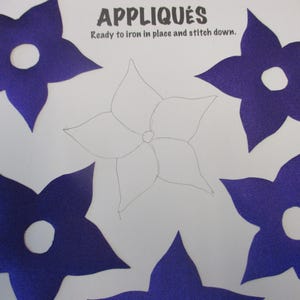 May include: Five purple felt flower appliques with a white center circle. The appliques are ready to iron in place and stitch down. The text "APPLIQUES" is at the top of the image. The text "Ready to iron in place and stitch down." is below the word "APPLIQUES".