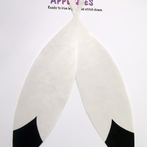 May include: Two white fabric appliques with black tips. The appliques are shaped like feathers and are ready to iron on and stitch down. The text "Appliques" is printed at the top of the image. The text "Ready to iron in and stitch down." is printed below the word "Appliques".